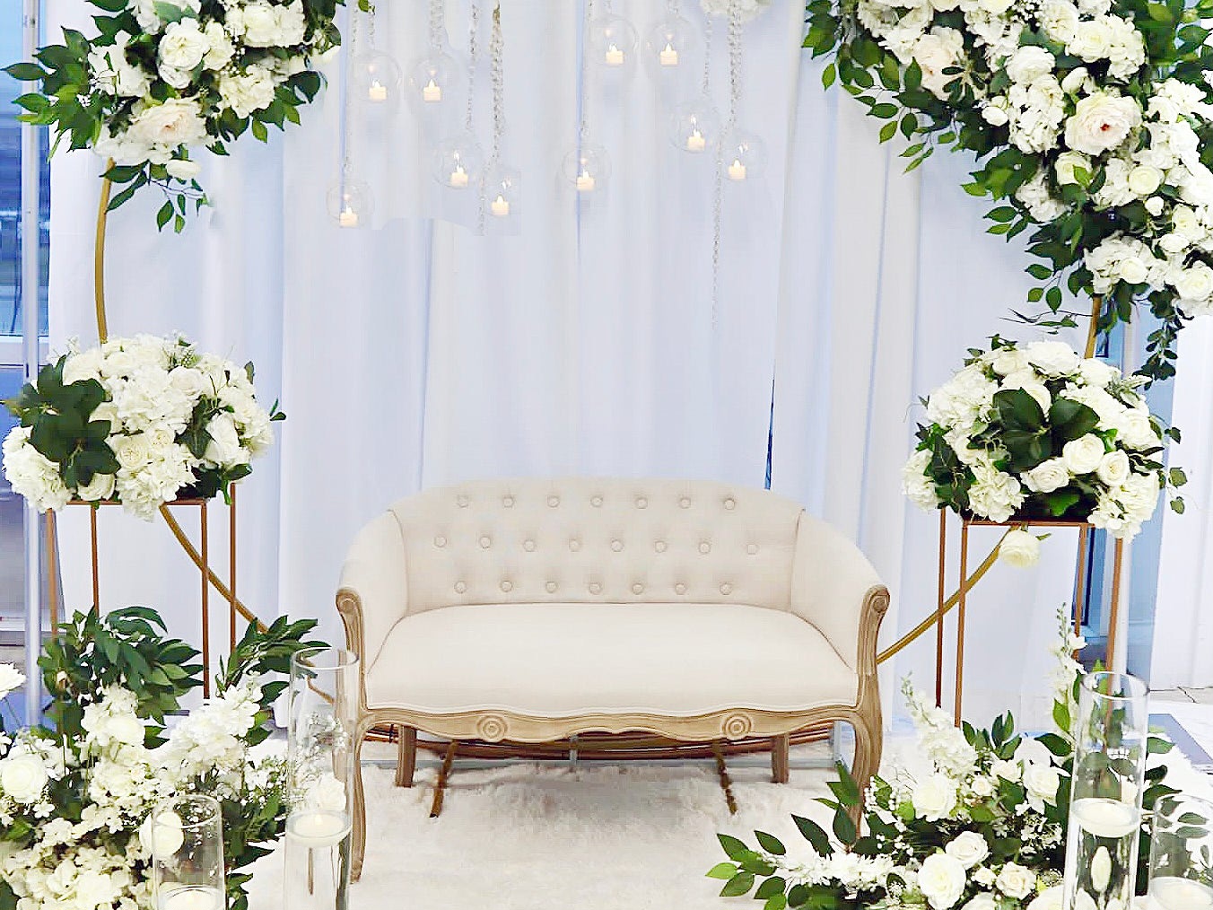 Budget-friendly wedding decor setup with drapes, floral centerpieces, and plastic chairs